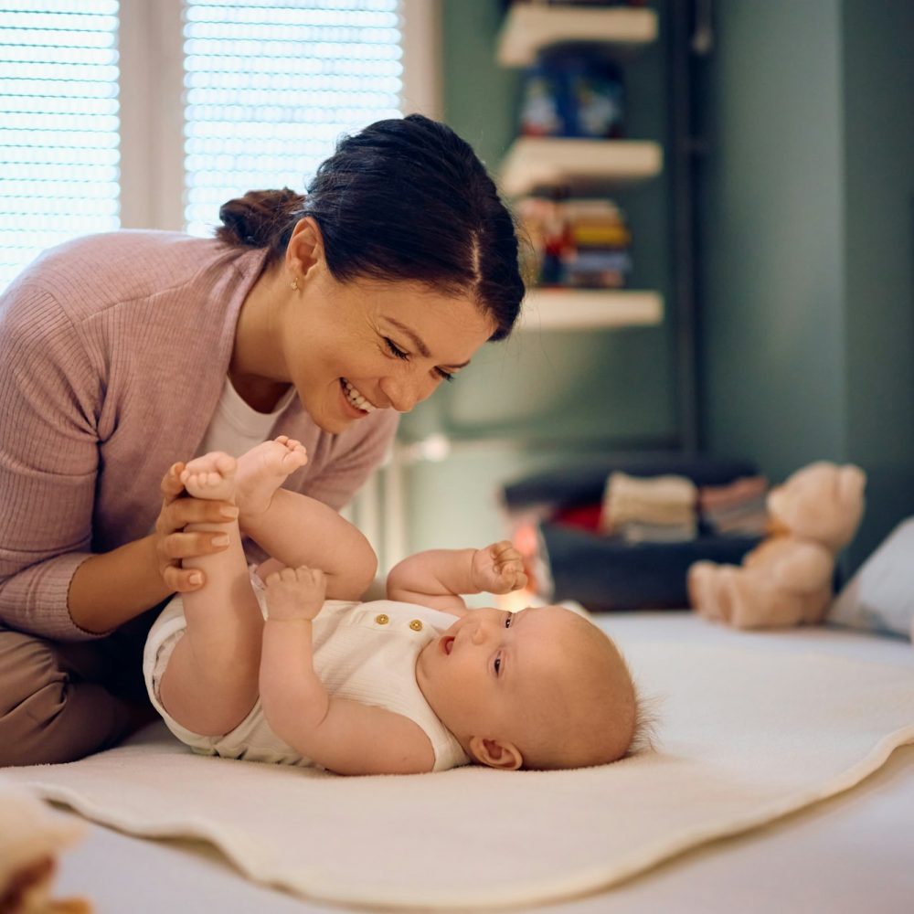 Happy mother having fun with her baby at home.